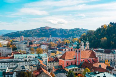 Güneşli bir sonbahar gününde kırmızı çatıları ve tepeleri olan renkli bir şehir. Ljubljana, Slovenya.