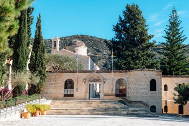 Kilisesi ve ağaçlarla çevrili basamakları olan taştan bir manastır. Kıbrıs 'taki Aziz Neophytos Manastırı.