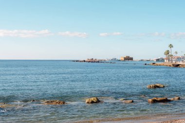 Mavi deniz manzarası ve ufuktaki ünlü Paphos Kalesi. Paphos, Kıbrıs.