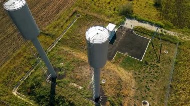 Hava perspektifi iki su kulesini canlı alanlar arasında yakalar, onların tasarımlarını ve çevrelerini vurgulayarak doğal manzara ve mekansal ilişkileri vurgular.