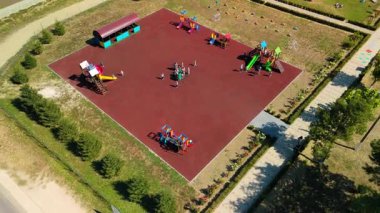 Hava perspektifi, çocukların slaytlar ve salıncaklarla meşgul olduğu neşeli atmosferi ve renkli oyun yapılarını vurgulayan canlı bir oyun alanı görüntüsü yakalıyor.