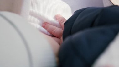 Küçük el yumuşak kumaşa dayanır, sıcaklığı ve hassasiyeti vurgular, kademeli olarak yakınlaşarak sahnenin duygusal bağlantısını ve samimiyetini arttırır.