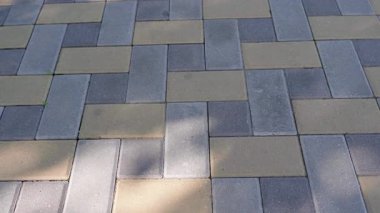 Sıralı çerçeveler, dış döşeme yüzeylerinin renk değişimlerini ve zanaatkarlığını vurgulayarak, eşsiz bir şablon içinde desenli kaldırım taşlarını ortaya koymaktadır.