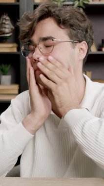 Yorgun genç adam esner ve elini ağzına tutar. Çocuk gözlüklerini çıkarır, gözlerini, ellerini ve boynunu uzatır. Öğrenim dönemi, dersler, sınavlar öğrenciler için çok zahmetli..