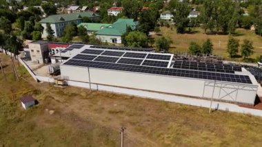 Hava perspektifi güneş panelleriyle donatılmış büyük bir yapı yakalar, enerji-verimli tasarım ve doğal çevrenin altını çizer, sürdürülebilirliği ve yeniliği vurgular