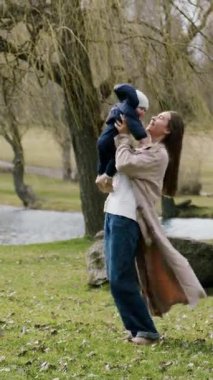 Kadın neşeli bir anda çocuğu kaldırıyor, sakin bir manzara tarafından çerçevelenmiş, kamera yukarı doğru eğildikçe, onların bağlantısını ve sahnenin güzelliğini vurguluyor.