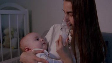 Bir anne sevgi dolu bir şekilde bebeğine solunum tedavisi uygular, besleyici atmosferi ve duygusal bağlantıyı vurgular, kamera yakınlaşır ve anı yakalar.