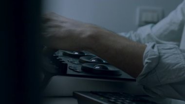 Gözlük takan bir adamın yakın çekimi, derin düşüncelere dalmış, kamera yavaşça yaklaşırken, lenslerindeki ince yansımaları yakalıyor, o anın duygusal atmosferini arttırıyor.