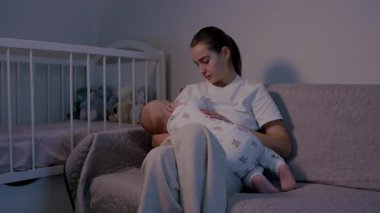 Besleyici bir anne bebeğini rahat bir kanepeye yatırır. Sıcak ve samimi bir sahne yaratır. Yumuşak ışık yumuşak atmosferi güçlendirir.