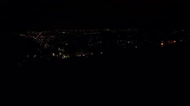 Gece şehir manzarası, ışık saçan ufuk çizgisinin çarpıcı bir görüntüsünü gözler önüne seriyor. Canlı ışıklar ve kentsel özelliklerle, kamera ufuk boyunca sorunsuzca hareket ediyor.