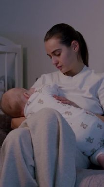 Besleyici bir anne bebeğini rahat bir kanepeye yatırır. Sıcak ve samimi bir sahne yaratır. Yumuşak ışık yumuşak atmosferi güçlendirir.