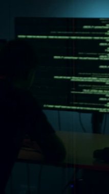 Siber güvenlik uzmanı bilgisayar korsanlığı faaliyetlerine daldı. Kodlarla dolu ekranlardaki verileri analiz etti. Kamera giderek artan gerilimi yakalamak için yakınlaştı.