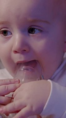 Bir anne bebeğine solunum terapisi uygular. Çocuğunuzun yüzüne yumuşak bir yakınlaşmayla samimi bakım ve rahatlık anını vurgular.