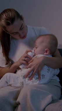 Bir anne, burun temizliği sırasında mızmız bebeğini rahatlatır. Bebeğini nazikçe tutarken aynı zamanda salin spreyi kullanır.