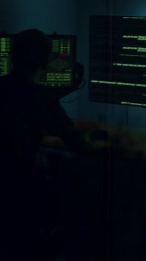 Aydınlatılmış bir teknoloji laboratuvarında kodlama yapan, birden fazla ekranla aydınlatılan, verileri gösteren, konsantrasyon ve yenilikleri vurgulayan bir kişi.