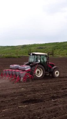 Tohumlu bir traktör, tarlaya tohumlar eker. Tarımsal teknikler ve mekanik hareketler gösterir.