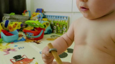 Bir bebek çeşitli oyuncakları keşfeder, tahta çubukları manipüle eder ve onları bir oyun paspasına dizer, oyuncu bir ortamda el-göz koordinasyonunu ve duyusal gelişimi geliştirir.