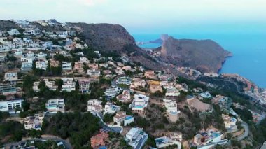 Hava perspektifi, yeşillikler arasında yuva yapmış dağ evlerini yakalar, engin okyanusları ve engebeli uçurumları gözler önüne sererek manzaralı güzellikleri ve mimari çeşitliliği vurgular.