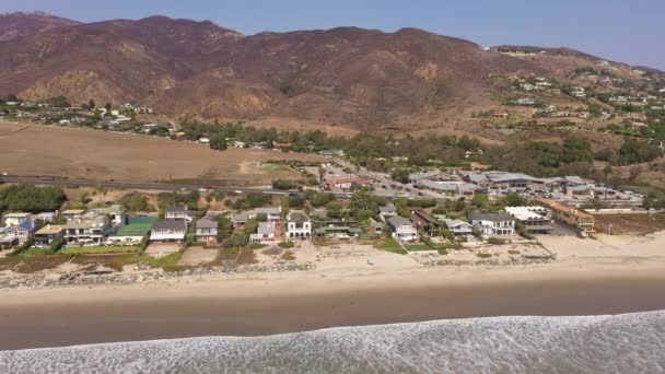 Aerial of beach homes and condos in Malibu with ocean and mountains — Stock Video