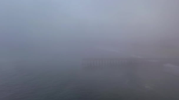 Drone vuela hacia Pismo Beach Pier durante condiciones de niebla — Vídeos de Stock