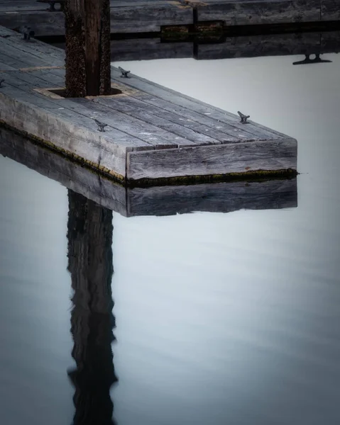 Reflexion des Bootsanlegeplatzes in ruhigem Wasser — Stockfoto