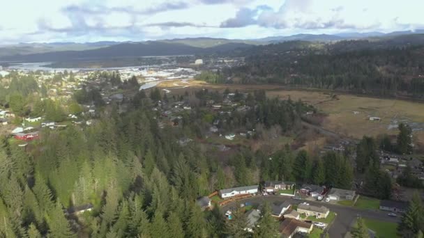 Drone dando vueltas sobre casas rurales en Coos Bay, revelando la vista de la bahía y slough — Vídeos de Stock