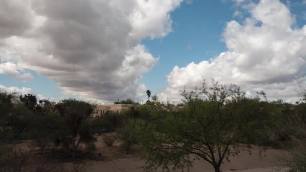 Time-lapse nuvola di un lavaggio nella comunità del deserto con costruzione nel retro — Video Stock