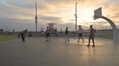 Kaliforniya Covid kısıtlamalarını kaldırdıktan sonra gençler sahilde basketbol oynuyor. 