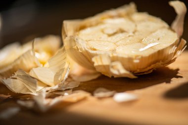 Kesme tahtasının üzerinde yarım sarımsak soğanı.