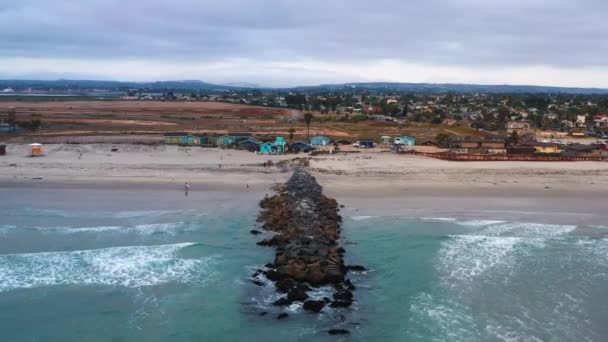 Jetty, surfistas y bungalows de playa en Imperial Beach, aéreo — Vídeo de stock