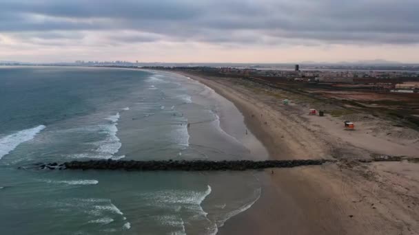 Surfistas en el océano por embarcadero en Imperial Beach San Diego California, plano aéreo 4k — Vídeo de stock