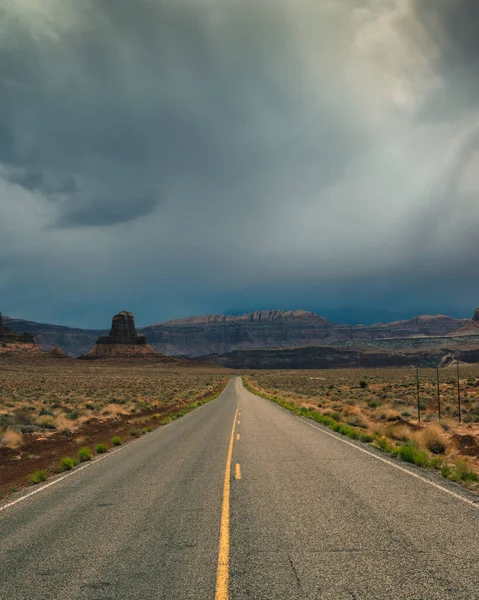 Utah 'ta uzun düz bir yol, dramatik bulutlar ve yağmur yağıyor.