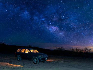 Jeep 'te yıldızların altında uyumak macera yolculuğu konsepti.