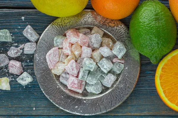 Citrus jelly candies in the bowl on the table and citrus - lime, lemon, orange