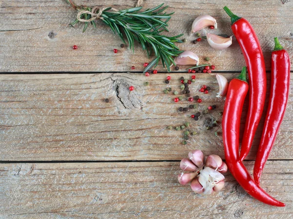 Condiments and spices - rosemary, garlic, pink and black pepper, chilli. top view, copy space