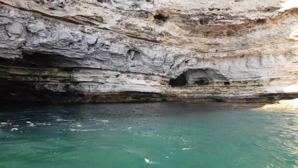 Acantilados empinados con cuevas. la costa del mar con una empinada costa de piedra. gargantas rocosas en el lado del mar. — Vídeos de Stock