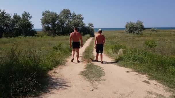 Padre Hijo Adolescente Están Caminando Largo Estrecho Camino Hacia Mar — Vídeo de stock