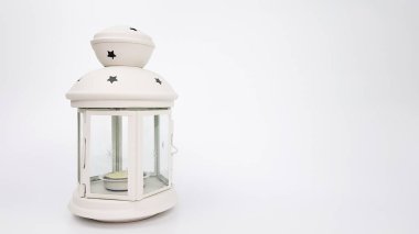 a Christmas candlestick in the form of a white lantern is isolated on a light background. space. background of the new year