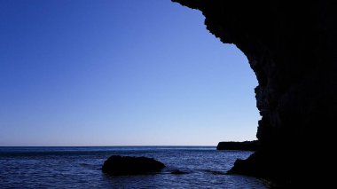 Denizde sarp kayalıklar. Mağara okyanus suyuyla dolu. Güzel deniz manzarası. dağların yakınına tekne gezisi