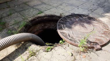Köknar ağacının yanındaki özel bir evin avlusunda kanalizasyon kanalı açın. Özel bir makineyle kanalizasyonu temizlemek