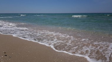 Temiz kumlu sahil güzel küçük deniz dalgaları. Yaz arkaplanı. Okyanus kumsalı