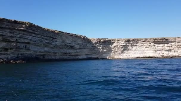 Скелі та круті береги з ущелинами були вилучені з яхти задоволення. відео з моря вид на скелі і бухти — стокове відео