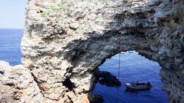 Yevpatoria, Rusya-29.06.2021. Balıkçılar sanayi ölçeğinde teknelerde balık yakalar. Kayalık deniz kıyısı. balıkçılık
