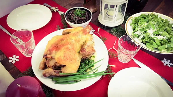 Pato de Natal tradicional na mesa festiva. jantar ou almoço com a família para o ano novo. mesa lindamente colocada com uma toalha de mesa vermelha em honra do feriado — Fotografia de Stock