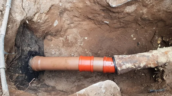 Il tubo fognario scoppiò. un foro scavato per la riparazione di tubi fognari. cura e manutenzione in una casa privata. — Foto Stock