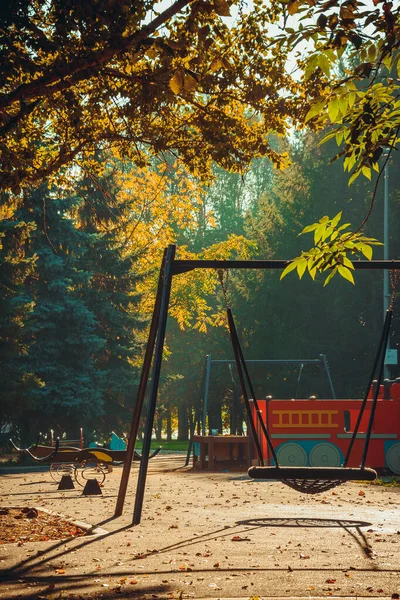 Gunga i parken.Höstlandskap med solljus på lekplatsen naturmiljö i parken under dagen natur bakgrund — Stockfoto