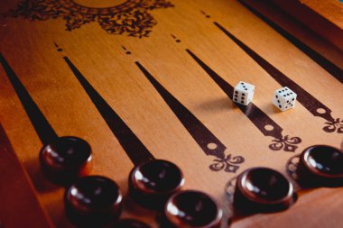 Tahta tavla oyunu. Tahta üzerinde zar oyunu. Tavla tahtası oyununda strateji ve rekabet. Tahta tavla tahtasında zar ve dama. Oyun zarları yüzeye yansıtılır