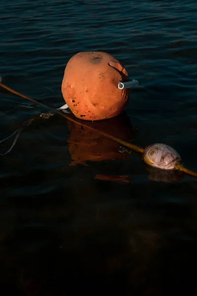 Uma bóia de mar laranja flutuante no mar. Bóia de barco laranja no mar. fronteira da zona balnear. A bóia laranja na água do mar escuro — Fotografia de Stock