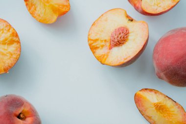 Şeftali taze ve ince dilimlere bölünmüş. Arka planda hafif bir arka plan görüntüsü. Yatay resim