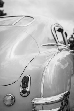 Siyah ve beyaz renkli farları olan klasik bir arabanın arkası. Farlar parlak krom ile bitti. Duvardaki poster konsepti..